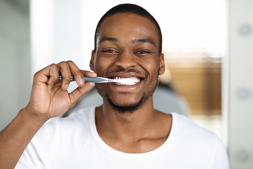 man cleaning teeth to improve teeth health