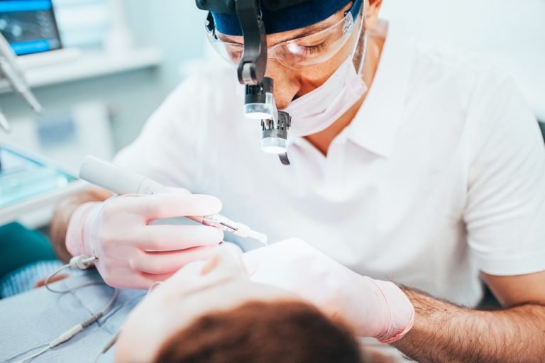dentist performing treatment on patient's teeth