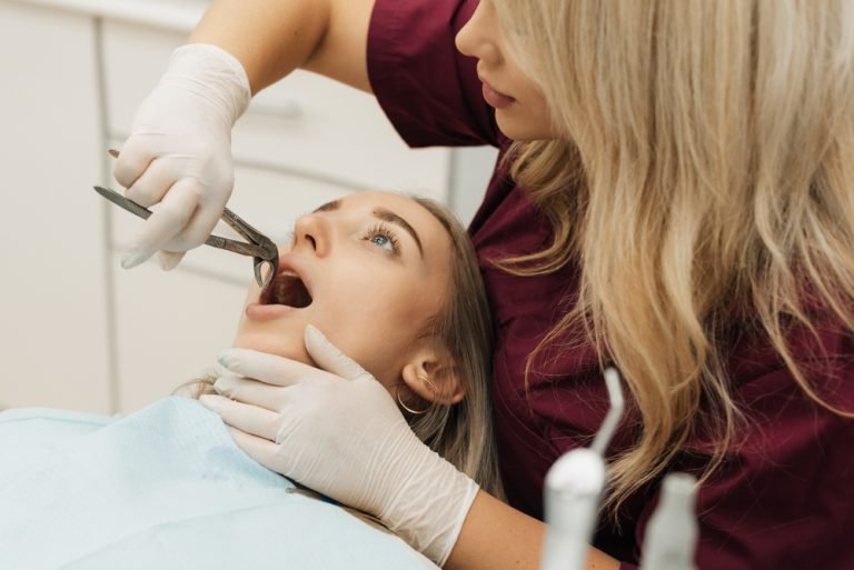 young lady having a tooth extraction performed by a dentist