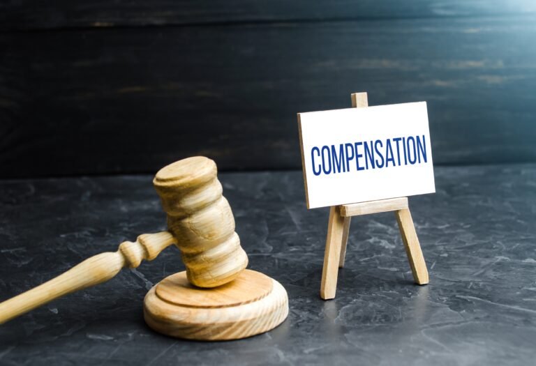 A gavel next to a sign that reads 'compensation'